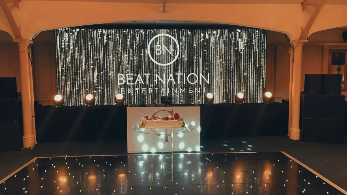 A silver curtain backdrop with the Beat Nation logo above a starlit dance floor
