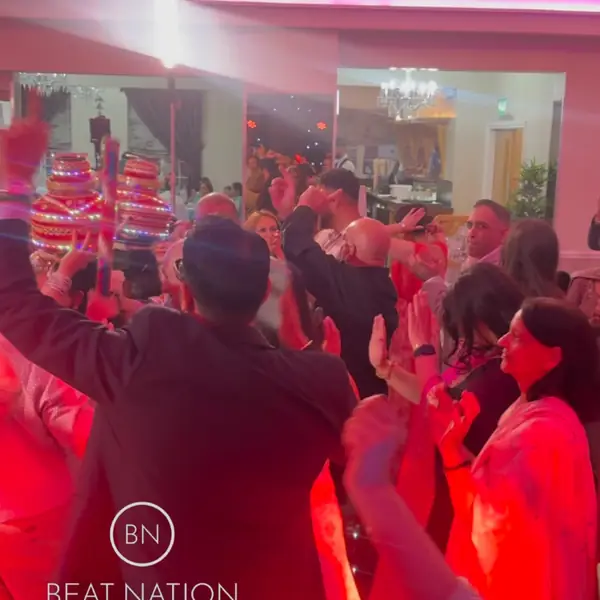 A full dance floor under pink lights at a pre-wedding night