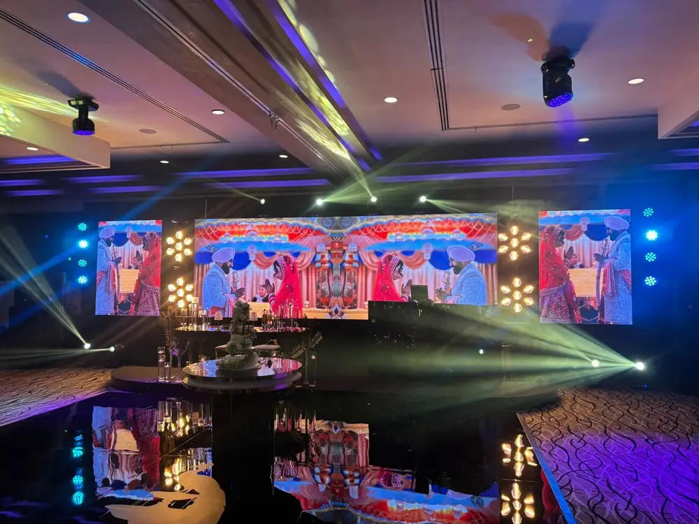 A wedding stage with an LED wall, moving lights and a mirrored dance floor